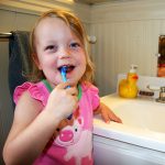 Girl Brushing teeth Total Orthodontics
